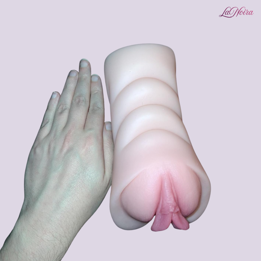 Intimax Twin Delight pocket stroker placed beside a hand to demonstrate overall size, length, and ergonomic shape