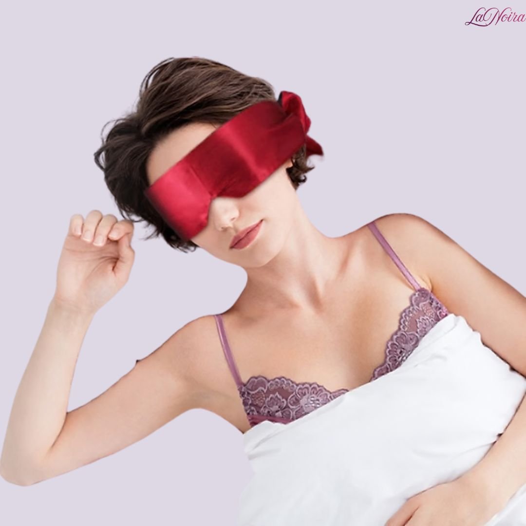 Red and black satin blindfolds with ribbon ties shown alongside model wearing blindfold
