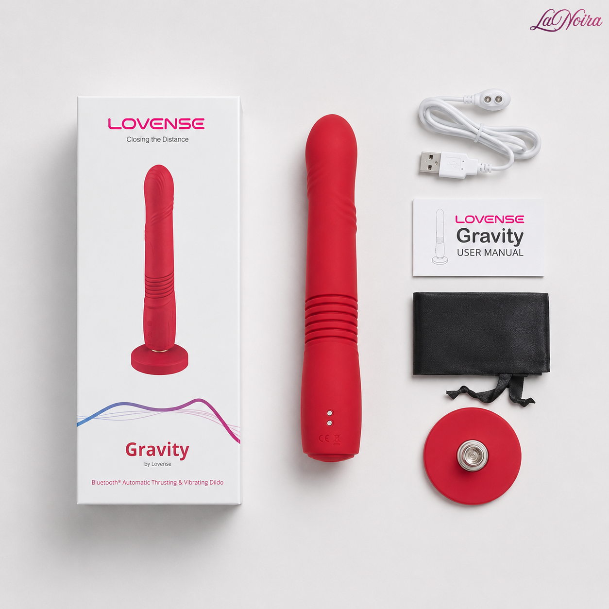 Lovense Gravity package contents including the G-spot massager, magnetic USB charging cable, storage pouch, suction cup base, user manual, and retail packaging arranged in a flat lay.